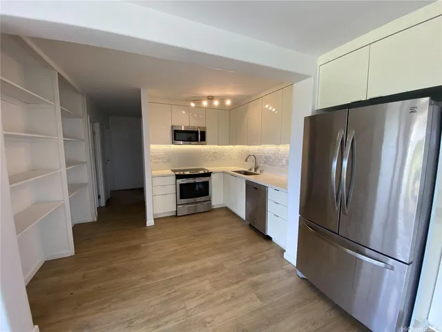 a kitchen with stainless steel appliances a refrigerator sink and cabinets