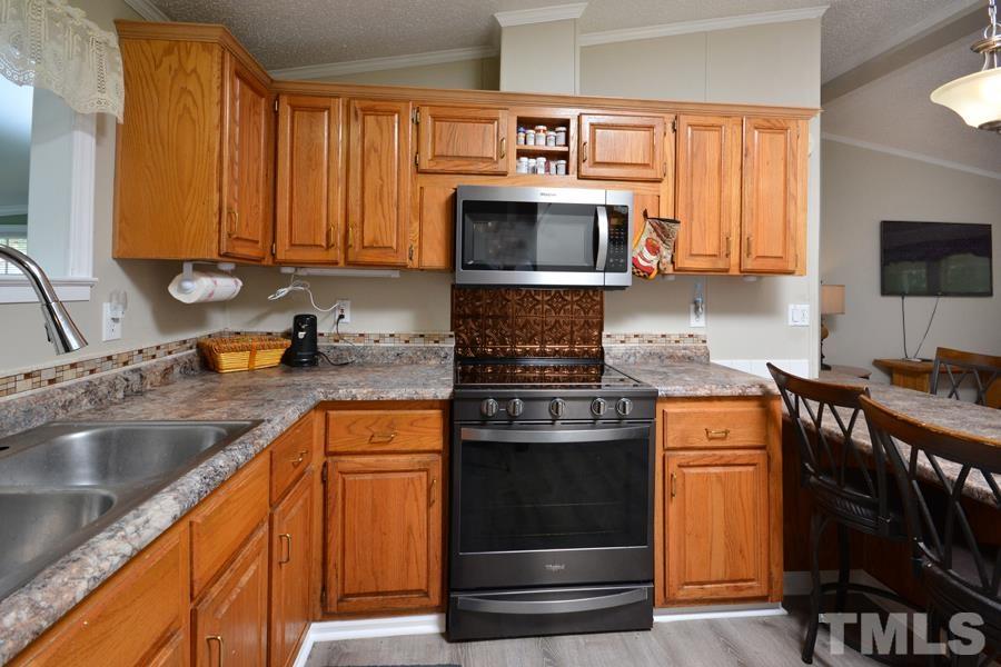 548 Duke Drive Rougemont, NC 27572 - Photo 2 of 43 a kitchen with stainless steel appliances granite countertop a stove a sink and a microwave