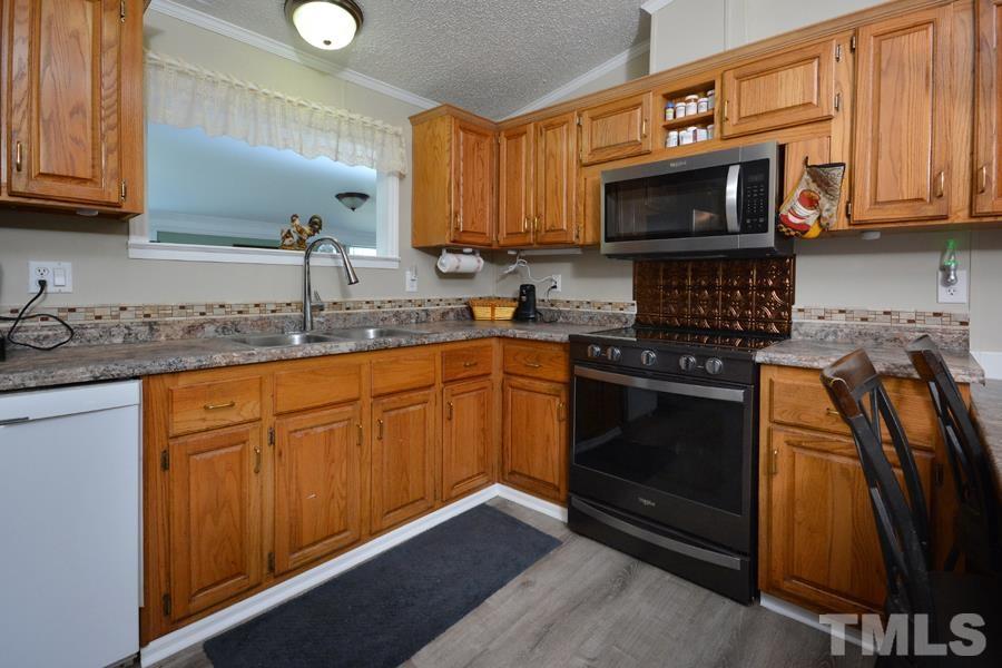 548 Duke Drive Rougemont, NC 27572 - Photo 4 of 43 a kitchen with stainless steel appliances granite countertop a sink stove and microwave