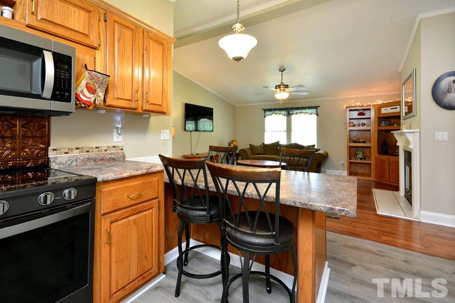 548 Duke Drive Rougemont, NC 27572 - Photo 8 of 43 a kitchen with stainless steel appliances granite countertop a stove a refrigerator a kitchen island a dining table and chairs with wooden floor
