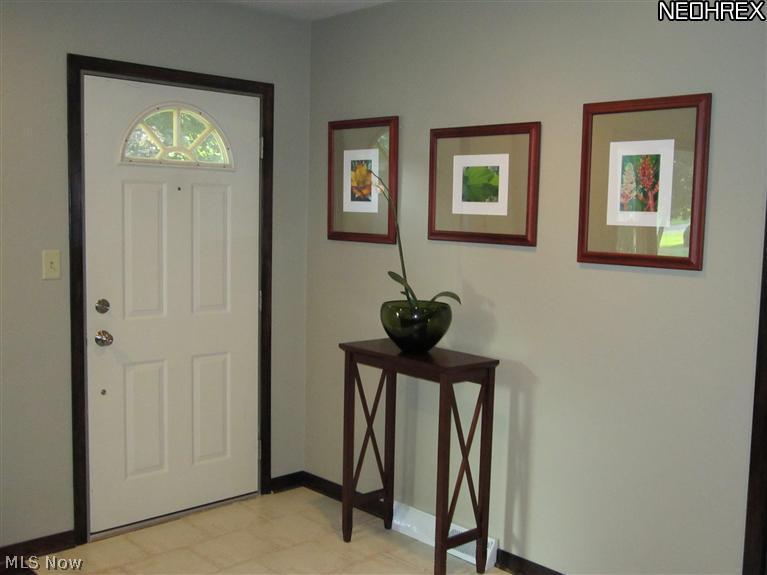 3206 Grill Road Clinton, OH 44216 - Photo 24 of 24 homeowner opened up this older floor plan - removed 60's era kickwall with planter and created open concept living area with ceramix flooring at entrance, and beautiful rich walnut flooring in living room