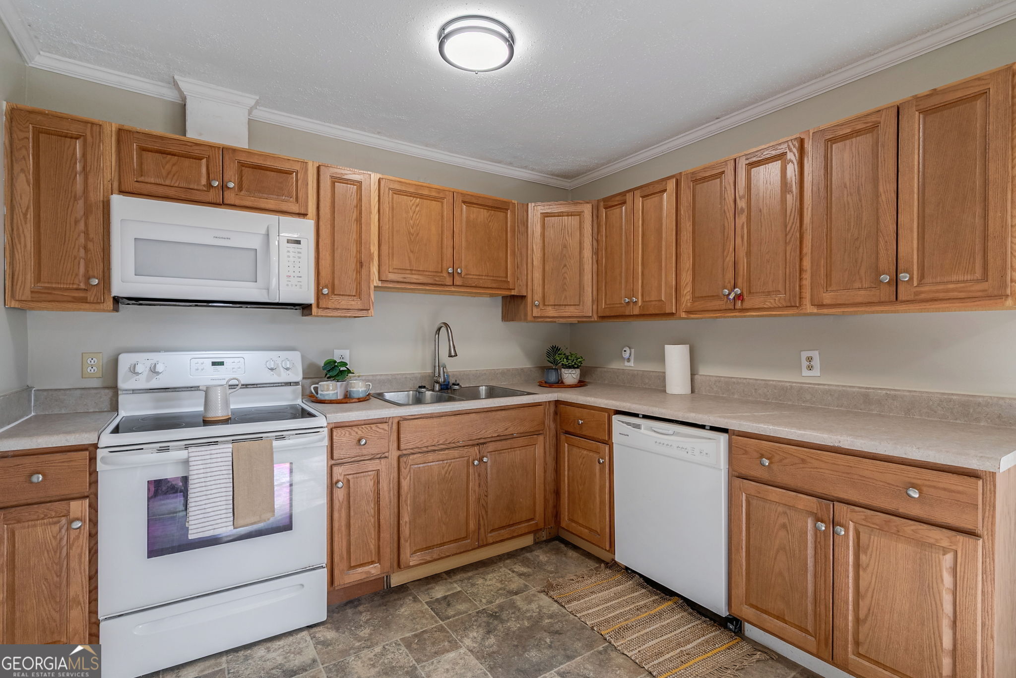 252 Raytown Road Northeast Crawfordville, GA 30631 - Photo 10 of 36 a kitchen with a sink stove and cabinets