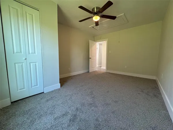 an empty room with closet and fan