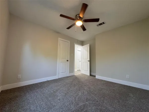 a view of a livingroom with a ceiling fan and window