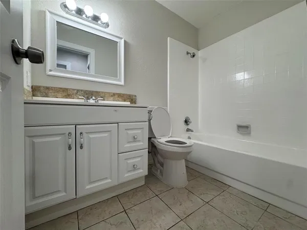 a spacious bathroom with a toilet sink and mirror