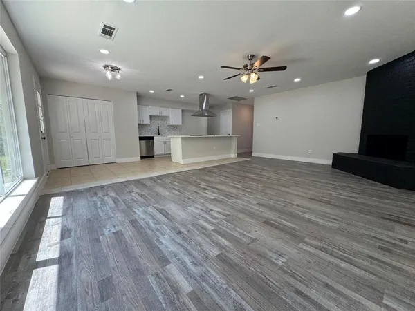 an empty room with kitchen and stainless steel appliances