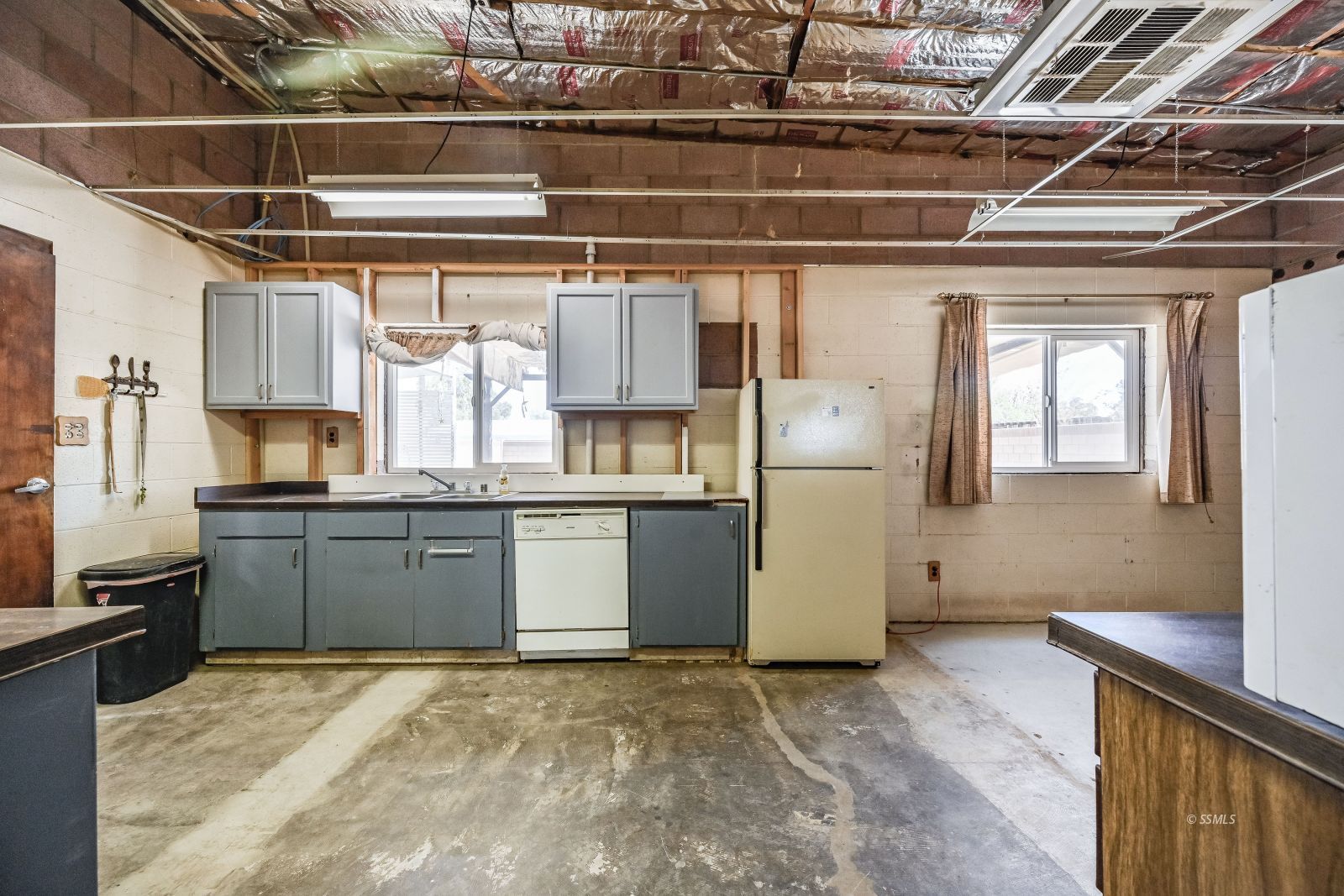 1572 North Calvert Boulevard Ridgecrest, CA 93555 - Photo 12 of 27 a kitchen with a refrigerator and wooden cabinets