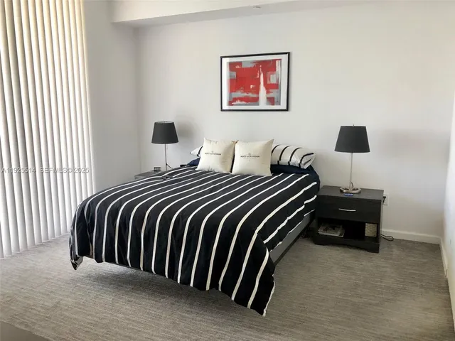 a bedroom with a bed and a wall painting