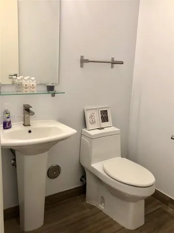 a white toilet sitting next to a bathroom sink