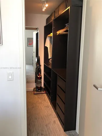 a view of walk in closet with clothes and shoes