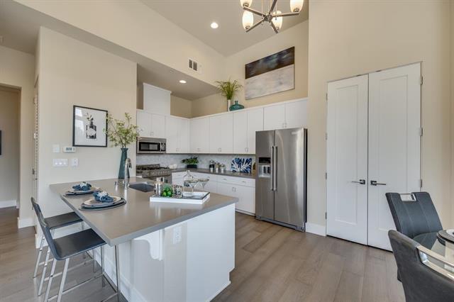 889 North San Antonio Road, Unit 2000 Los Altos, CA 94022 - Photo 4 of 14 a kitchen with stainless steel appliances kitchen island granite countertop a refrigerator a stove a sink a dining table and chairs with wooden floor