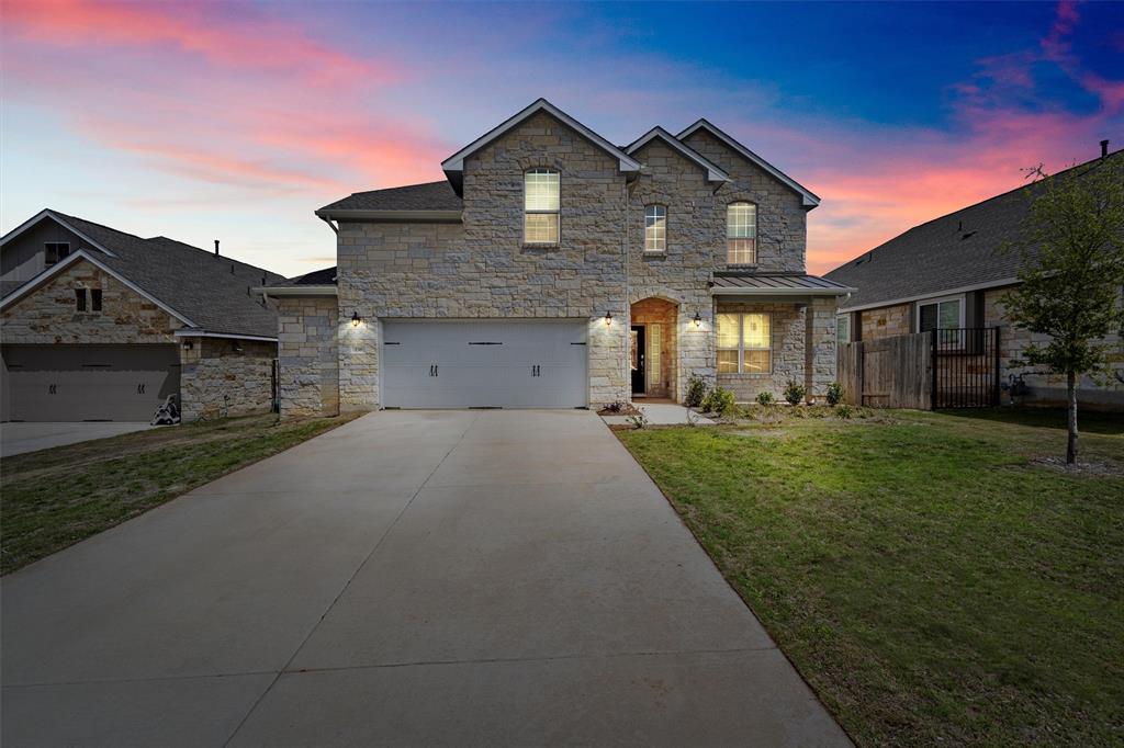 236 Prato Place Georgetown, TX 78628 - Photo 1 of 40 A striking stone facade with a spacious driveway invites you into this charming residence under a vibrant evening sky.