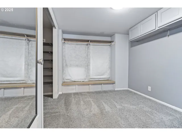 a view of an empty room with closet and a window