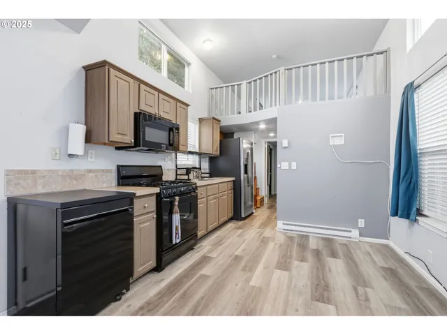 a kitchen with stainless steel appliances a refrigerator stove and microwave