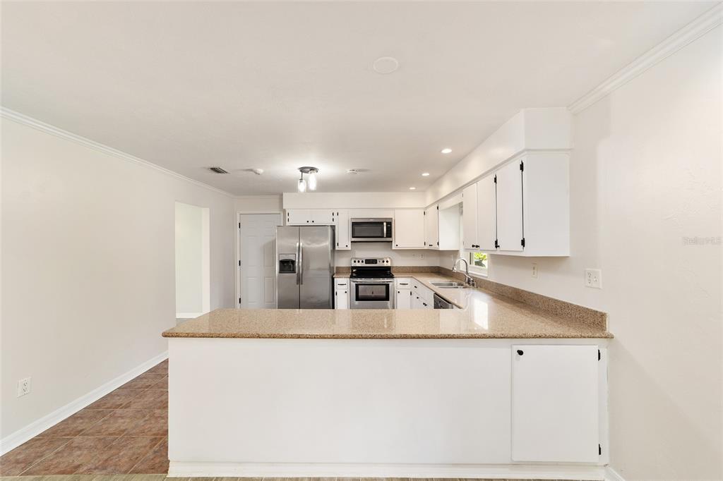 4805 Southwest 19th Street Gainesville, FL 32608 - Photo 17 of 43 a kitchen with stainless steel appliances granite countertop a sink and a refrigerator