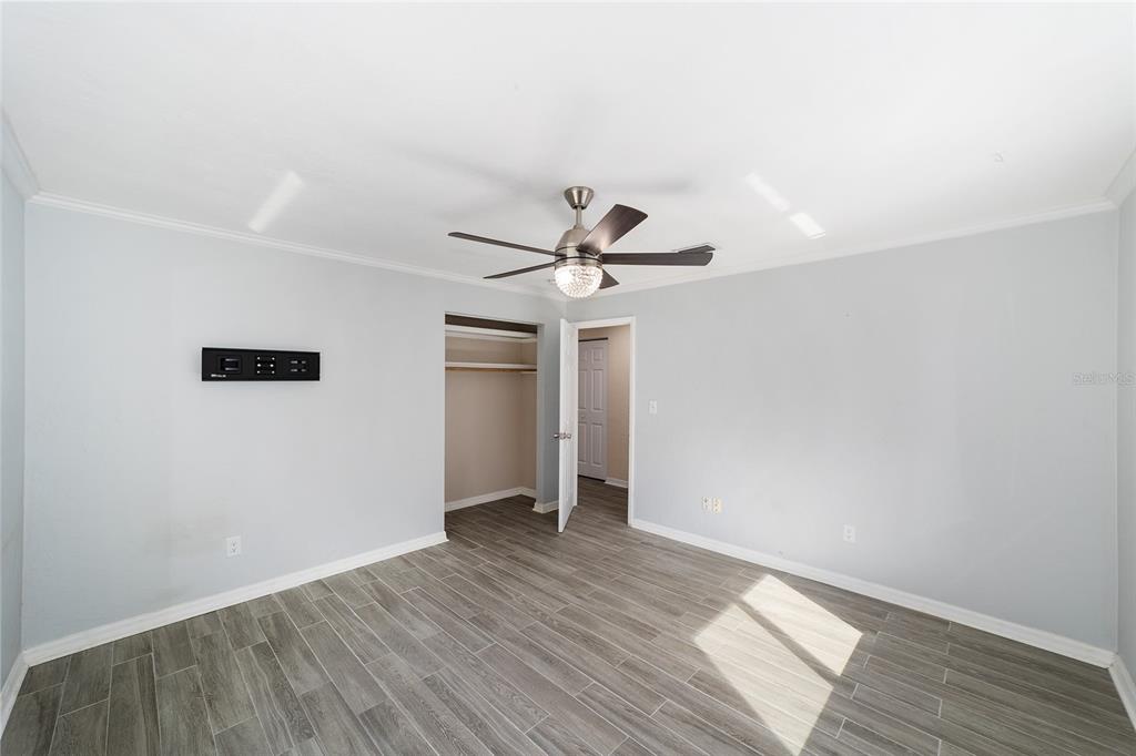4805 Southwest 19th Street Gainesville, FL 32608 - Photo 27 of 43 an empty room with wooden floor fan and windows