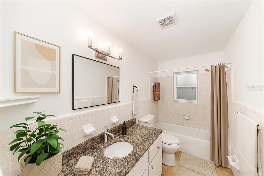 4805 Southwest 19th Street Gainesville, FL 32608 - Photo 28 of 43 a bathroom with a granite countertop sink toilet a mirror a vanity and shower