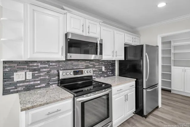 a kitchen with cabinets stainless steel appliances and a counter space