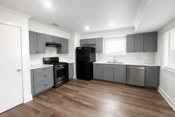 a kitchen with a refrigerator stove top oven and sink