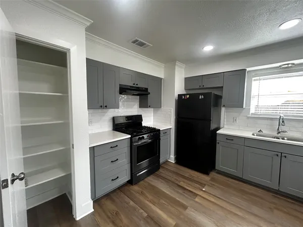 a kitchen with a refrigerator and a sink