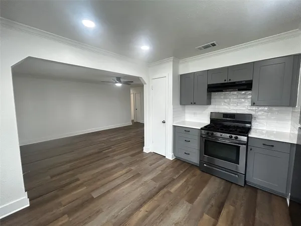 a kitchen with granite countertop a stove and a sink