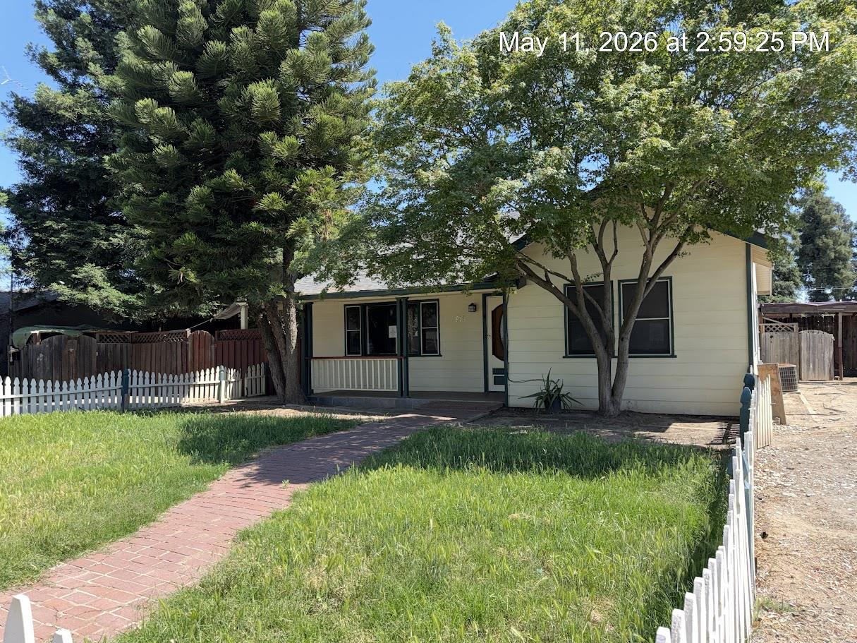 916 Elm Avenue Modesto, CA 95351 - Photo 1 of 52 1. Street view / full frontage A classic Elm Ave welcome — white picket fence, mature trees, and that storybook curb appeal that makes you slow down before you even park.