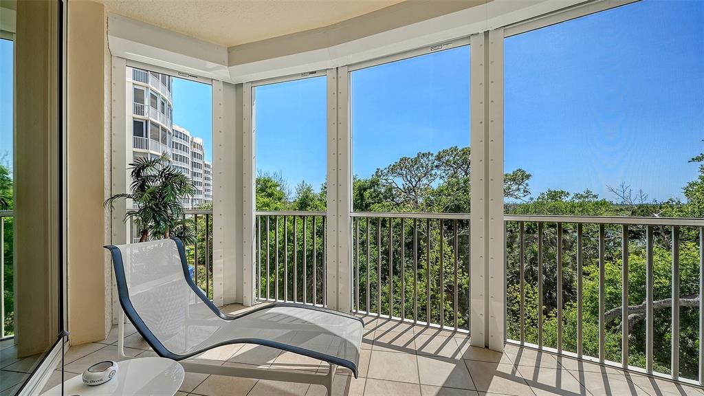 409 North Point Road, Unit 401 Osprey, FL 34229 - Photo 11 of 90 a view of a balcony with chair and glass door