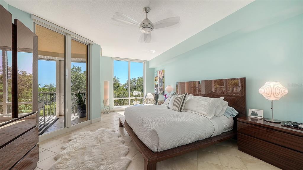 409 North Point Road, Unit 401 Osprey, FL 34229 - Photo 29 of 90 a bedroom with a large bed and a lamp on dresser