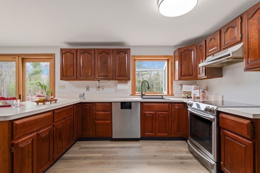 4 Darrell Drive North Reading, MA 01864 - Photo 15 of 41 a kitchen with stainless steel appliances granite countertop a sink stove cabinets and wooden floor