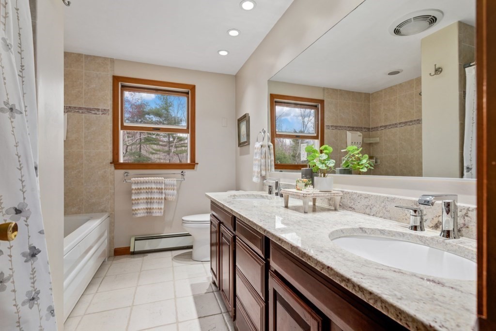4 Darrell Drive North Reading, MA 01864 - Photo 25 of 41 a spacious bathroom with a granite countertop sink a mirror a vanity and a bathtub