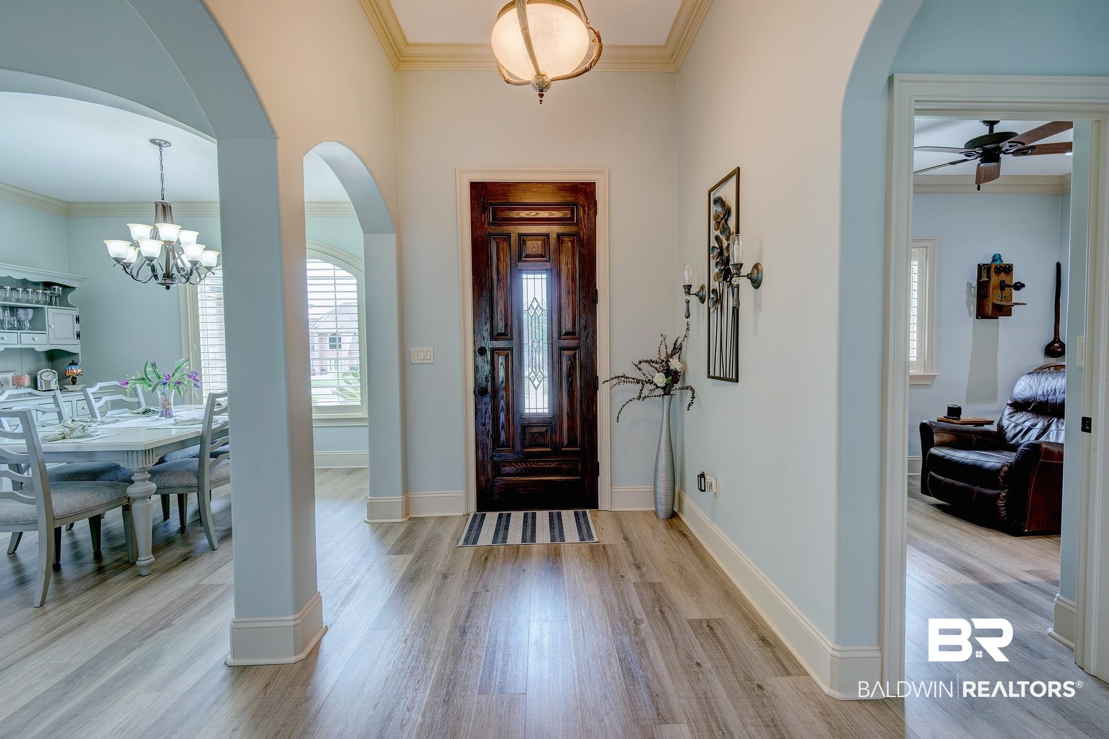 9357 Lakeview Drive Foley, AL 36535 - Photo 26 of 68 Entryway featuring wood-finish flooring, a detailed dark wood front door with leaded glass, archways, and crown molding