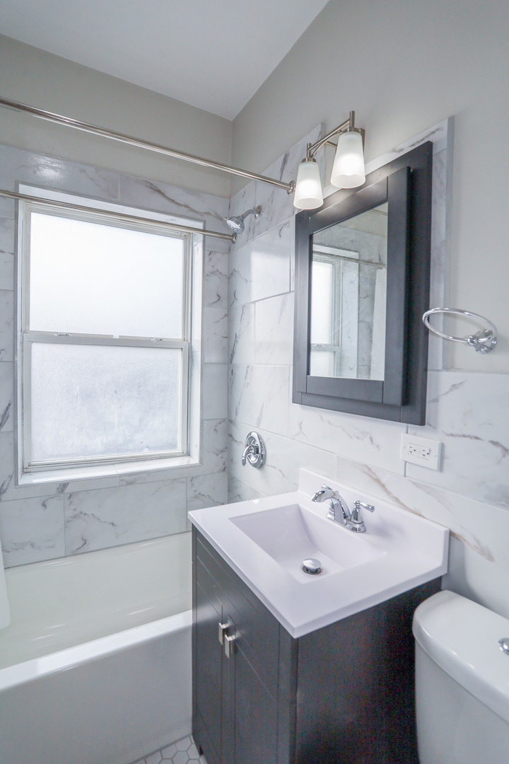 2712 North Milwaukee Avenue, Unit 314 Chicago, IL 60647 - Photo 4 of 7 a bathroom with a sink and a mirror
