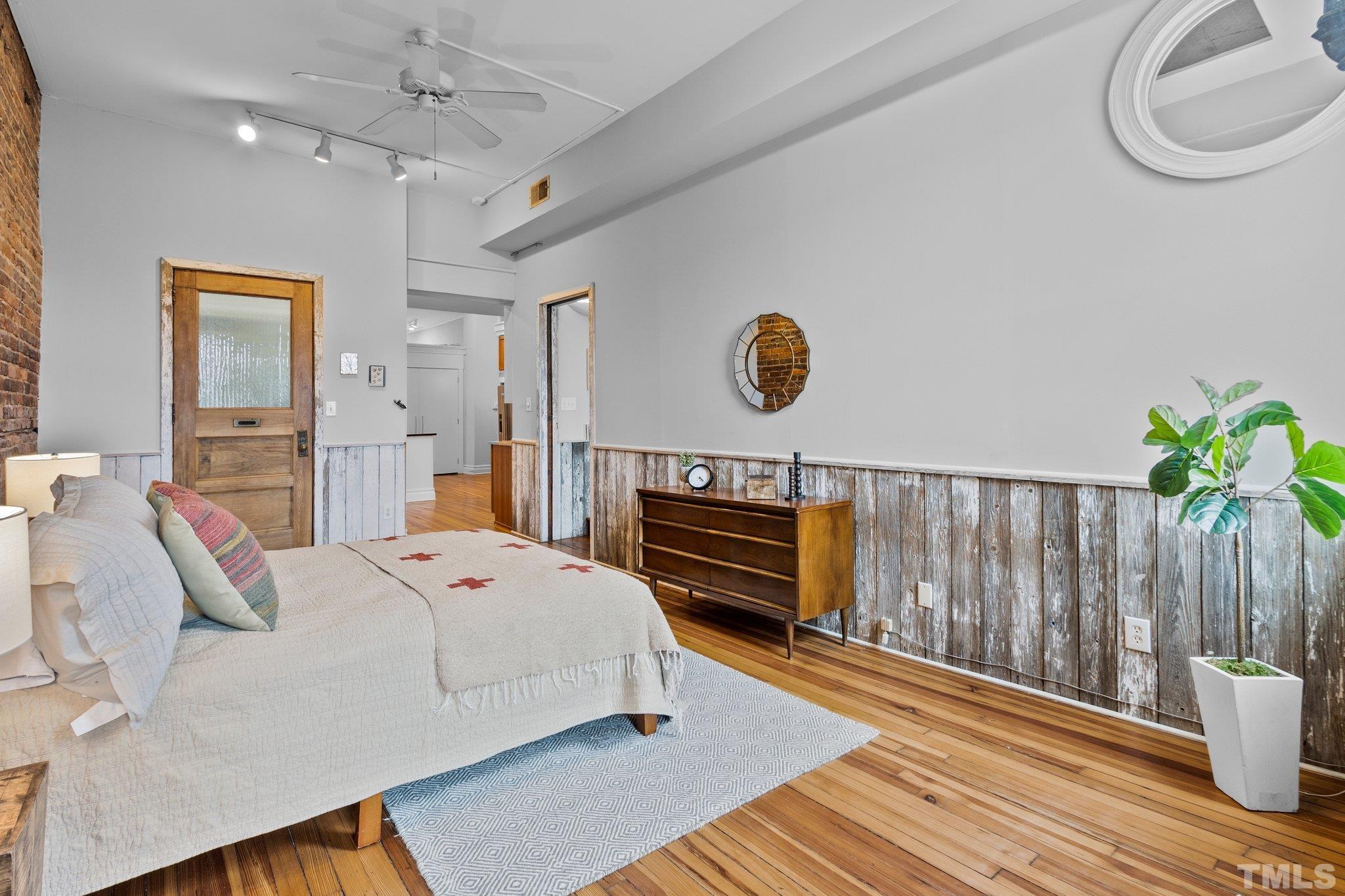 323 West Main Street, Unit J Durham, NC 27701 - Photo 15 of 36 a spacious bedroom with a bed a dresser and wooden floor