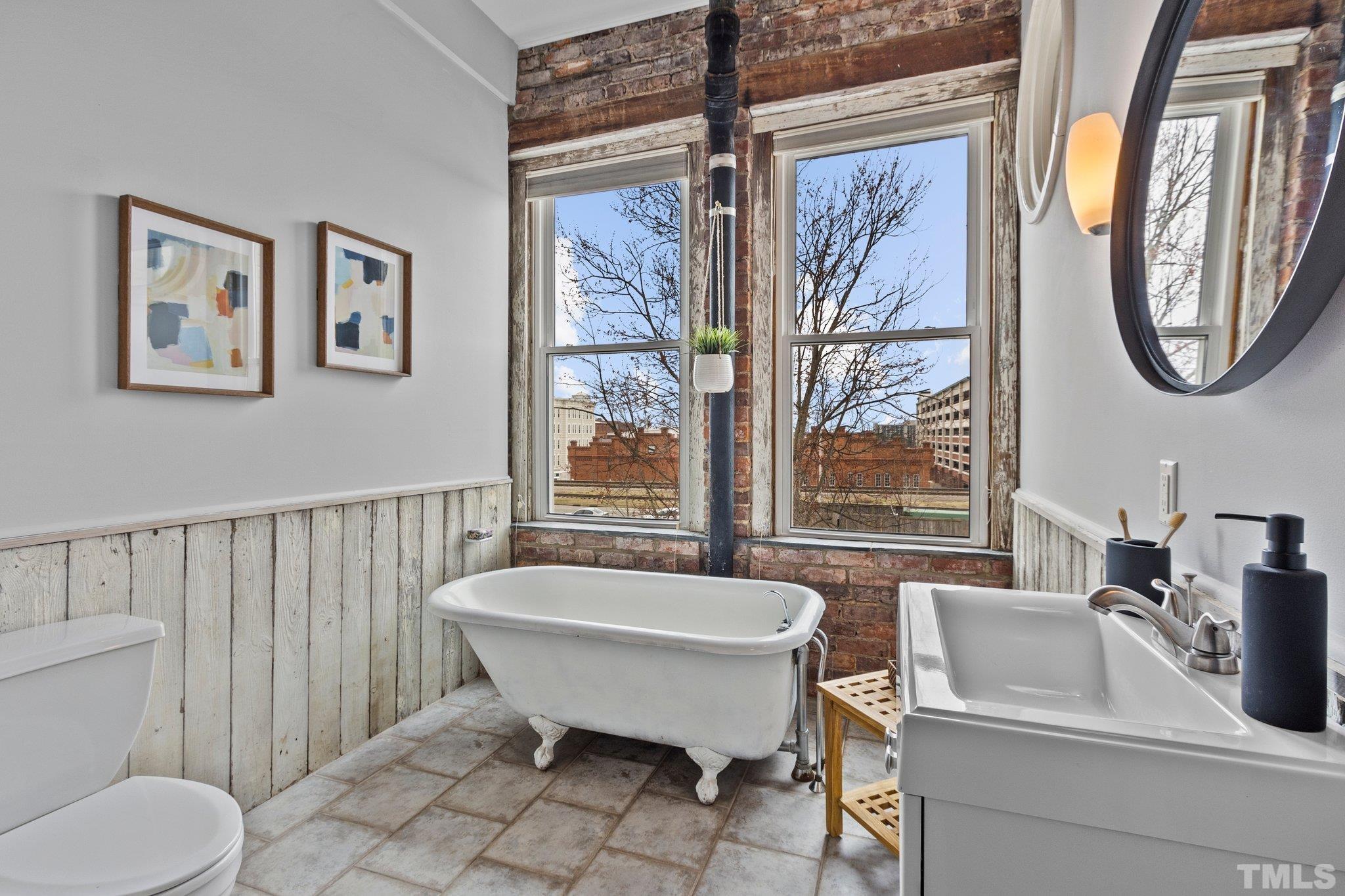 323 West Main Street, Unit J Durham, NC 27701 - Photo 17 of 36 a bathroom with a toilet a sink and a large mirror