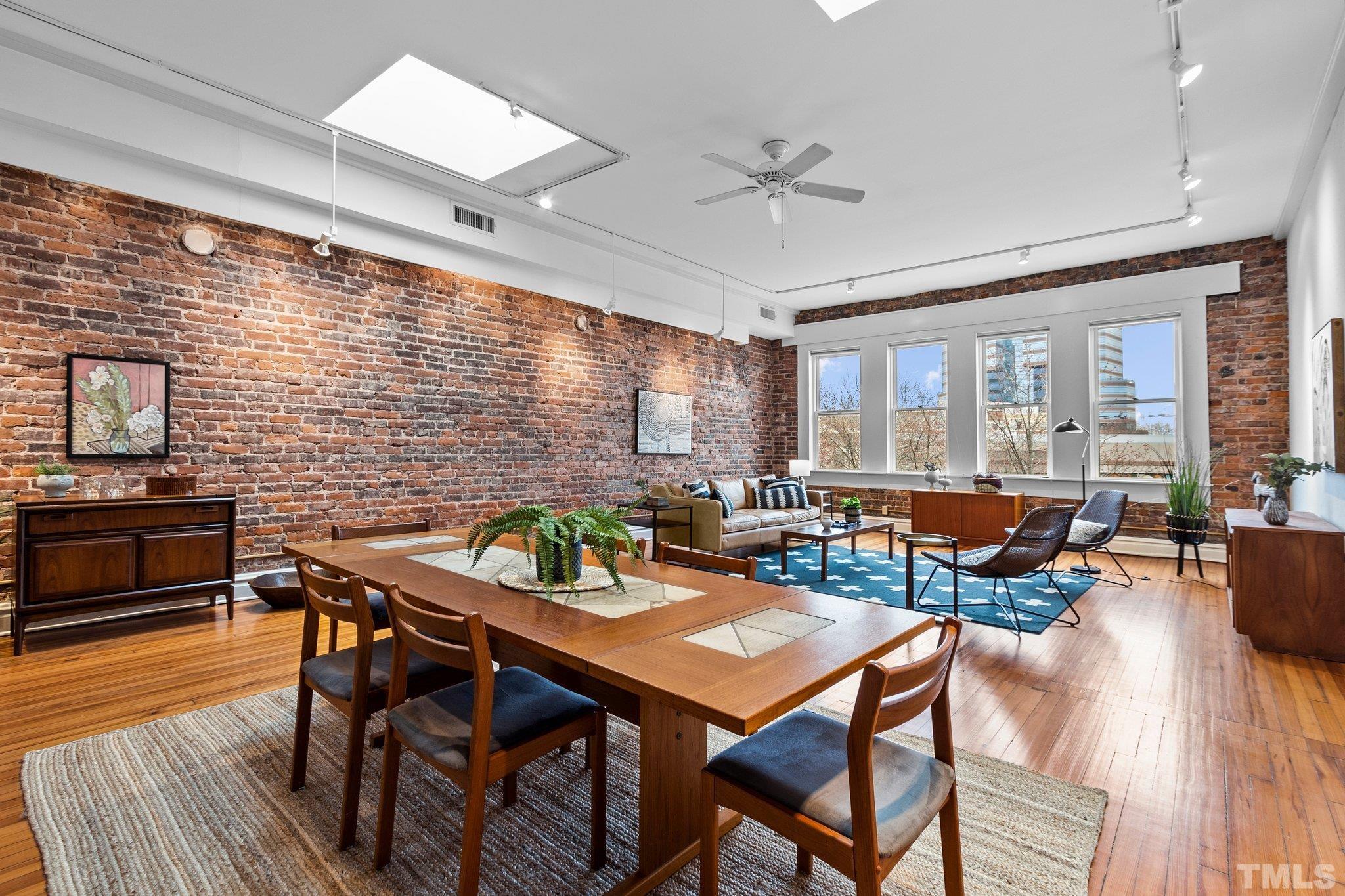323 West Main Street, Unit J Durham, NC 27701 - Photo 5 of 36 a living room with patio furniture and a wooden floor