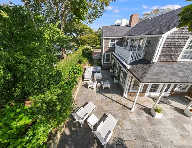 a view of a patio with couches table and chairs and potted plants