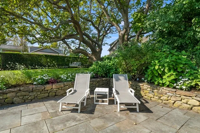 a view of a patio with table and chairs potted plants