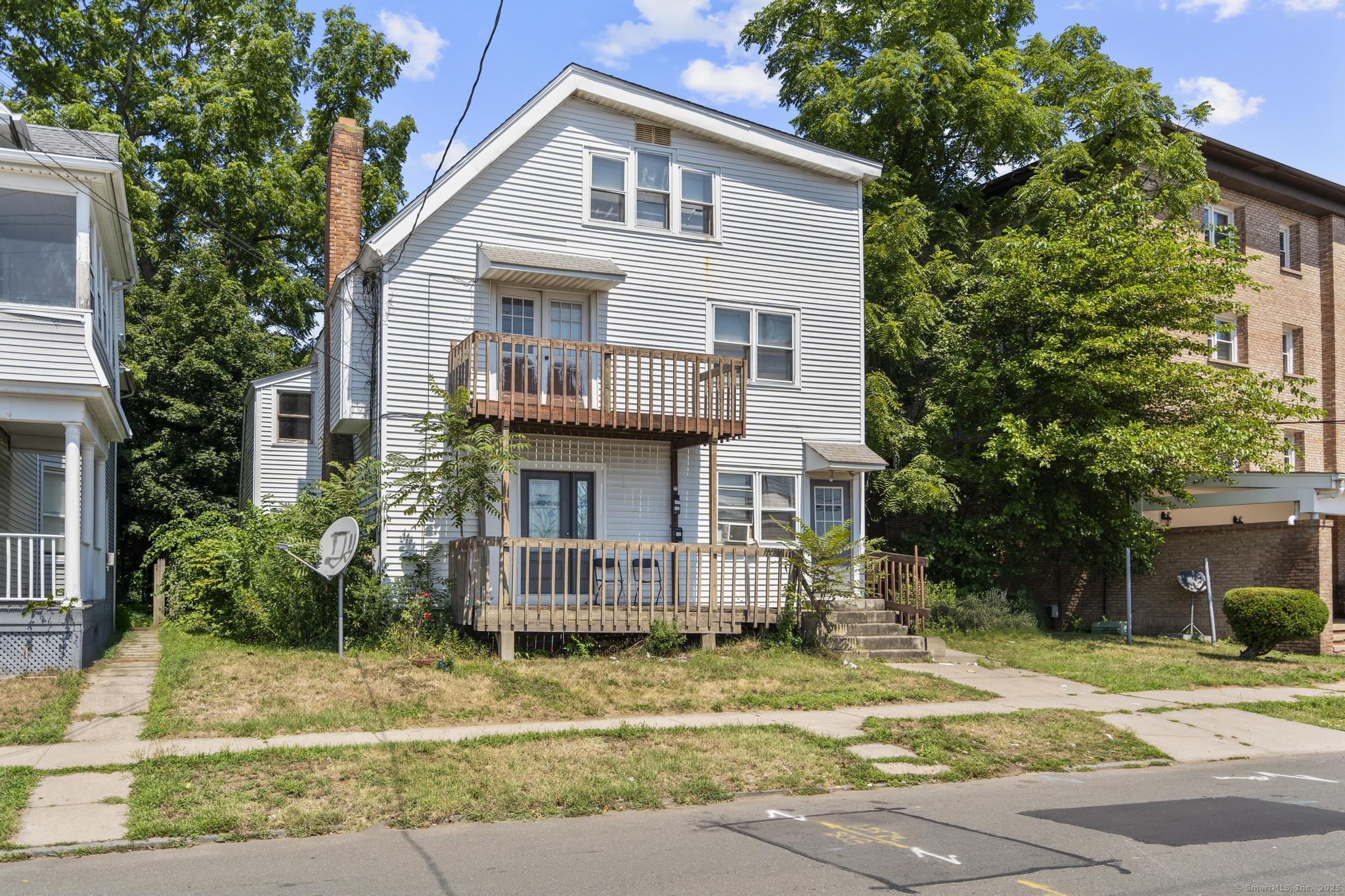 327 Center Street West Haven, CT 06516 - Photo 3 of 19 a view of a white house with a small yard plants and large tree