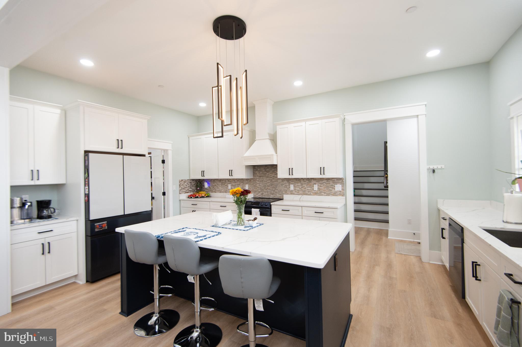 9509 Rum Ridge Road Delmar, MD 21875 - Photo 13 of 76 a kitchen with stainless steel appliances kitchen island granite countertop a sink a stove a refrigerator and island with wooden floor