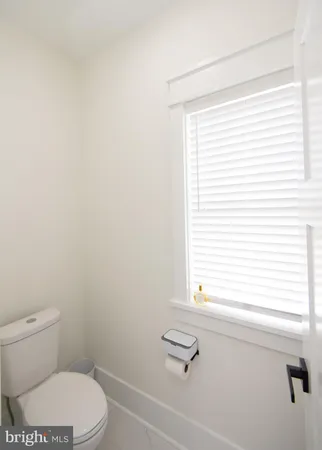 a white toilet sitting next to a bathroom sink and vanity
