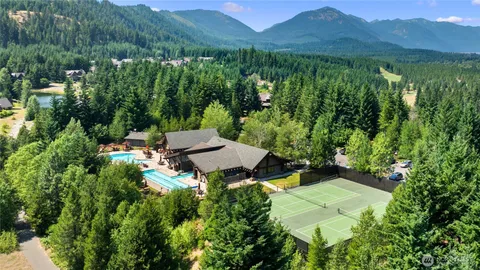 a view of a lush green forest with a house