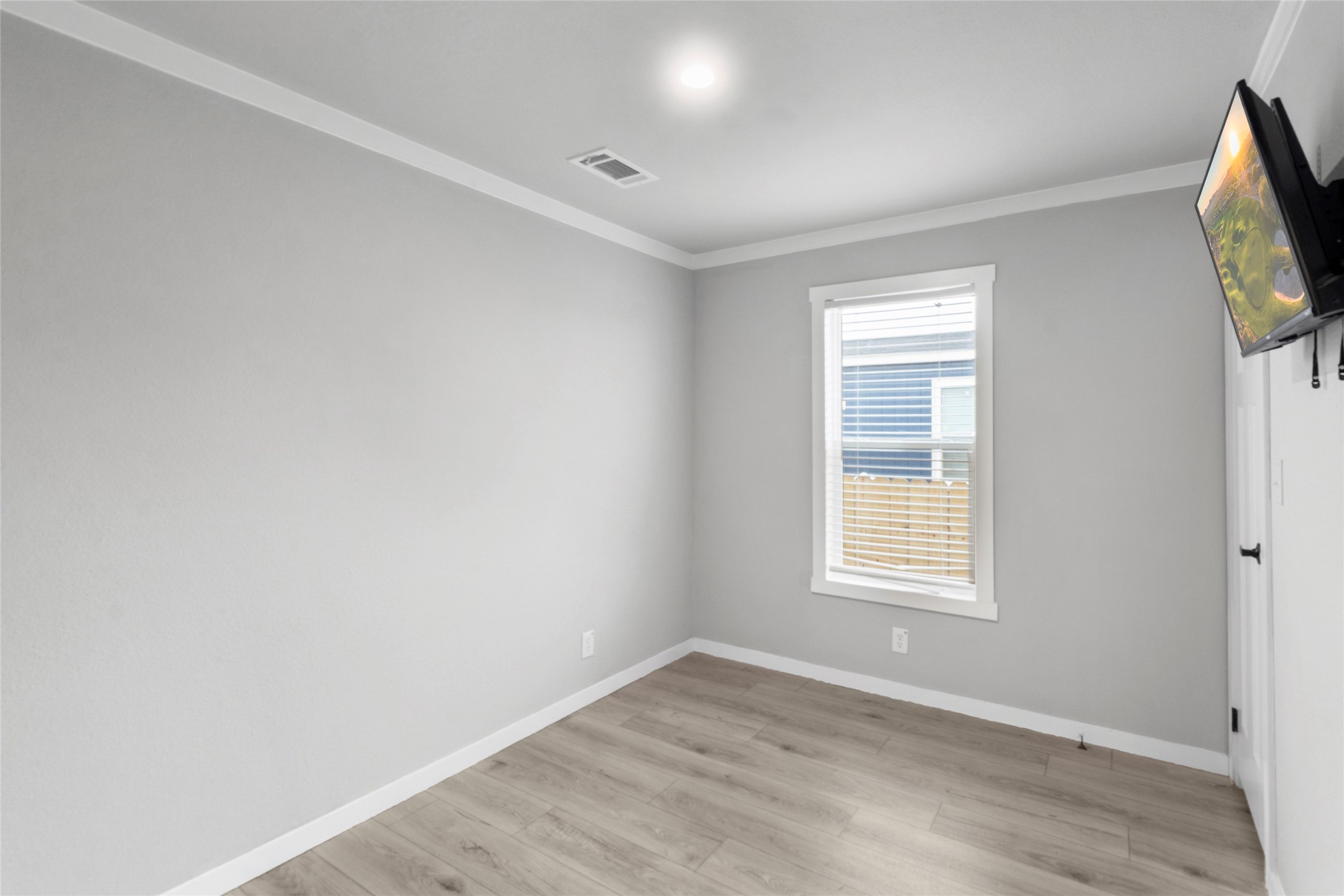119 Mooney Road Pearland, TX 77581 - Photo 13 of 25 an empty room with wooden floor and windows