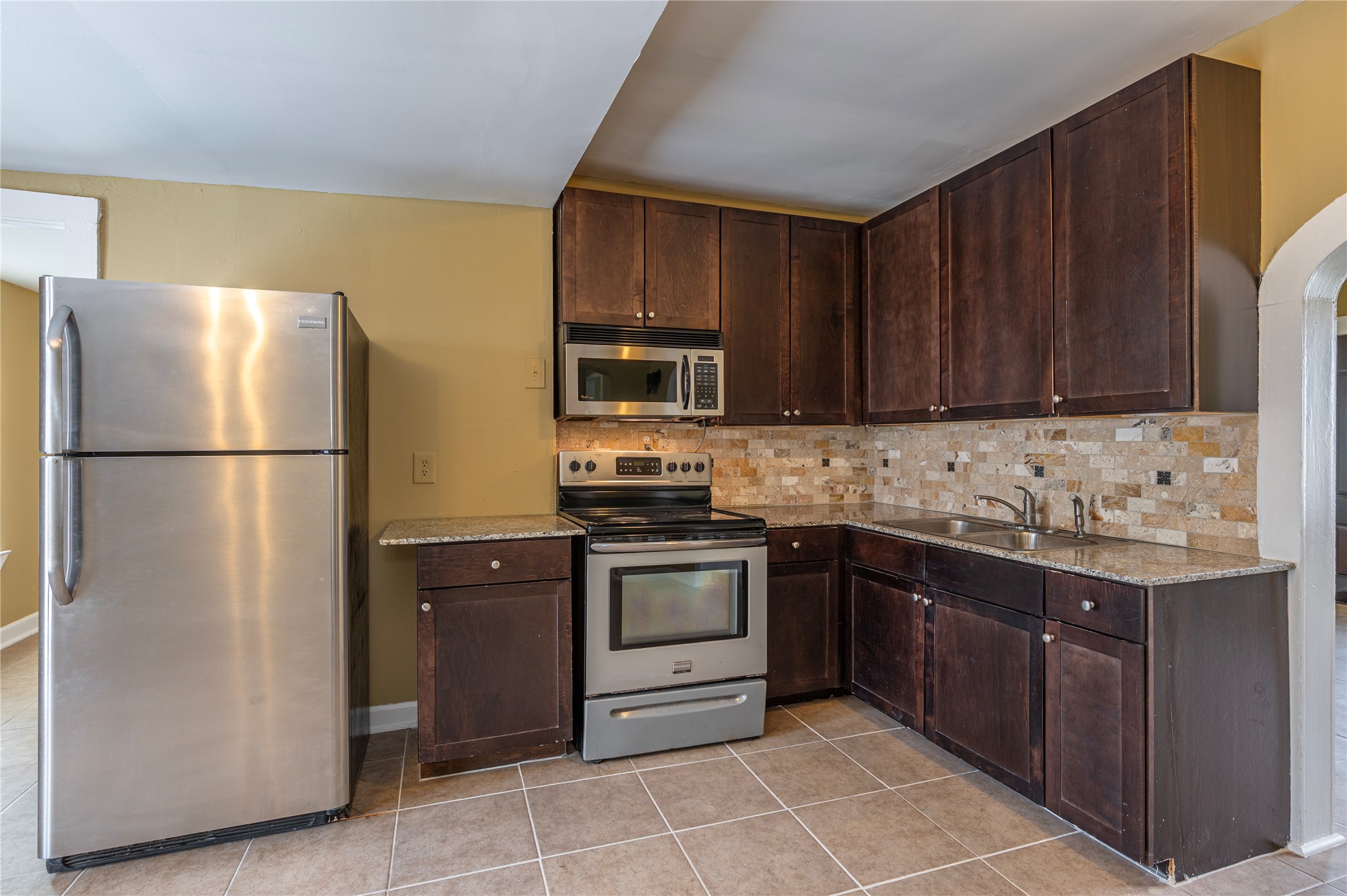 805 Chestnut Street La Marque, TX 77568 - Photo 11 of 26 a kitchen with stainless steel appliances granite countertop a refrigerator stove a sink and dishwasher