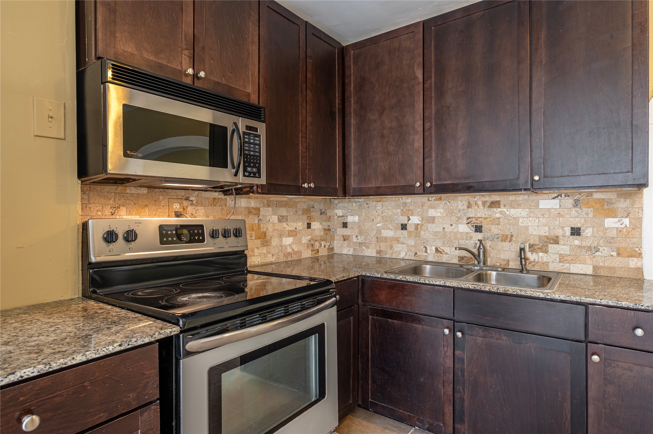 805 Chestnut Street La Marque, TX 77568 - Photo 10 of 26 a kitchen with granite countertop wooden cabinets and a stove top oven