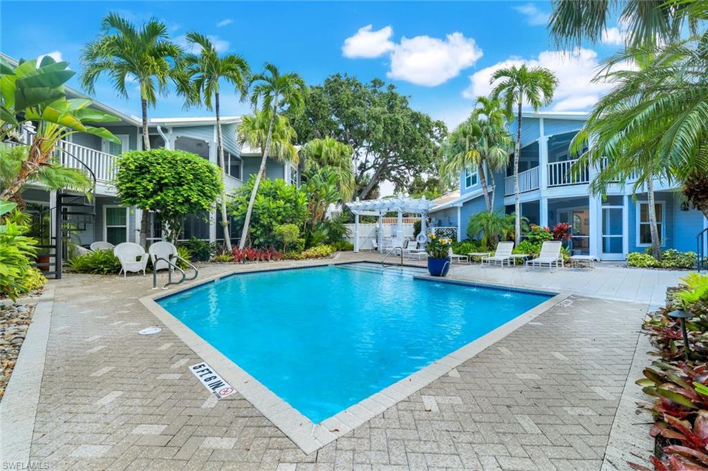 376 3rd Street South, Unit 102 Naples, FL 34102 - Photo 1 of 17 Community pool featuring a patio area, a balcony, a sunroom, and a pergola