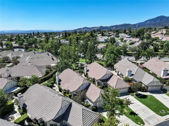 a front view of a house with a yard and mountain view in back