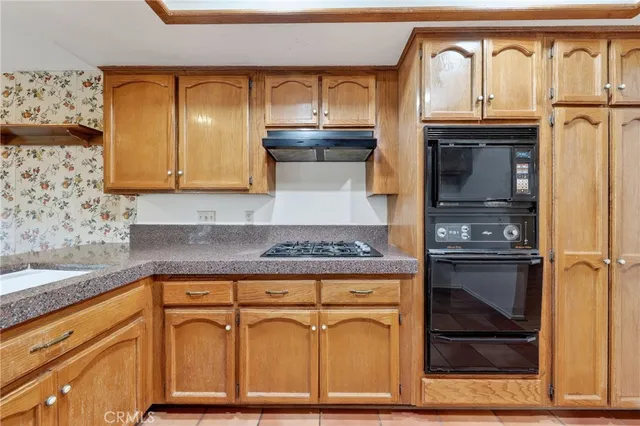 a kitchen with granite countertop a stove and cabinets