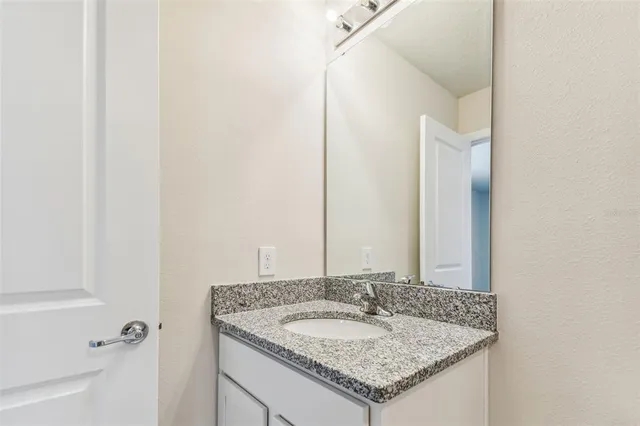 a bathroom with a granite countertop sink a toilet and bathtub