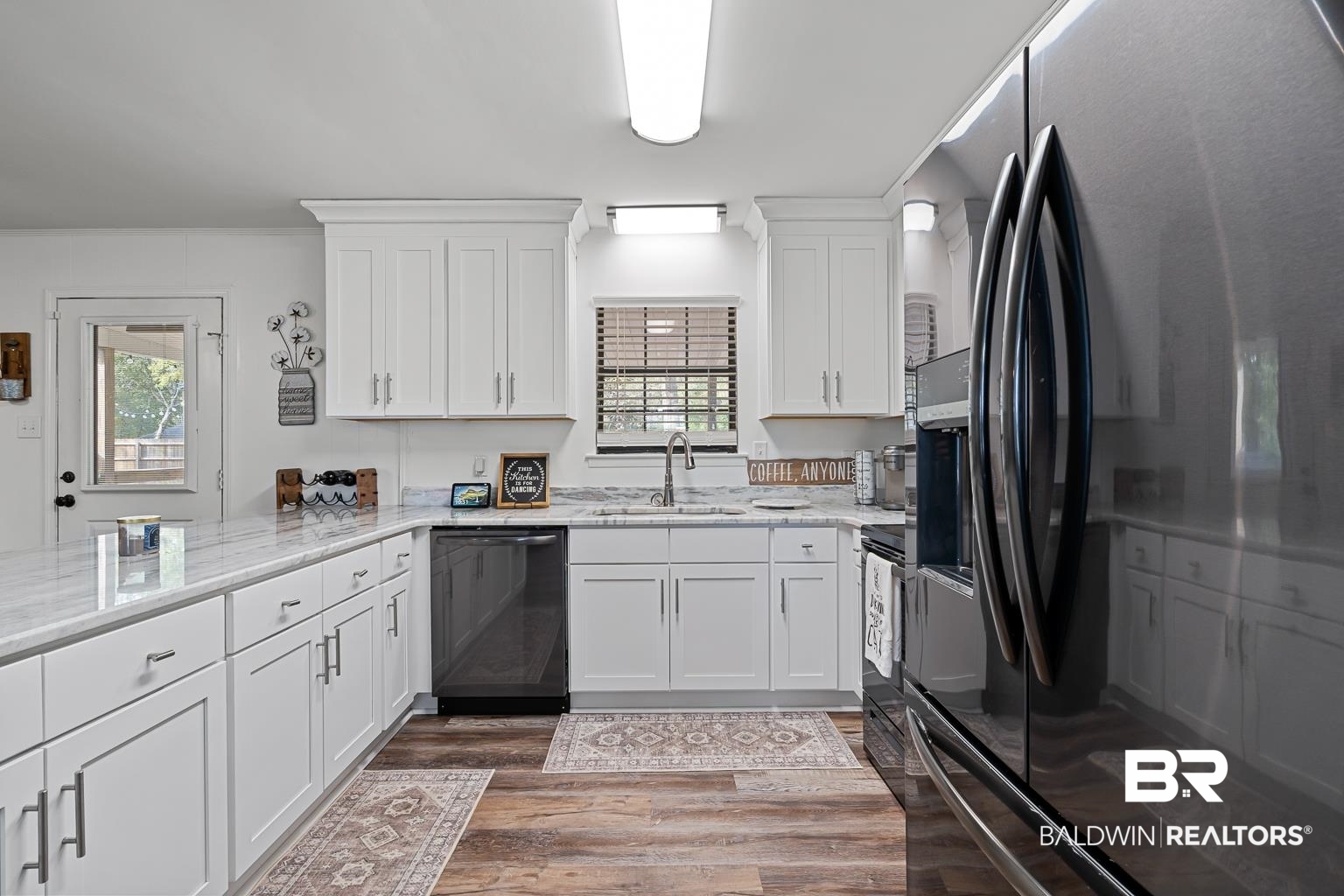 6801 Piney Woods Road Foley, AL 36535 - Photo 37 of 74 Kitchen with stainless steel fridge with ice dispenser, white cabinetry, dishwashing machine, light stone countertops, and dark wood-style flooring