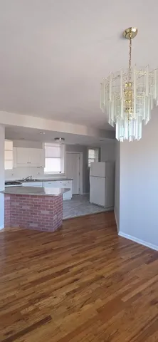 a view of empty room with window and wooden floor